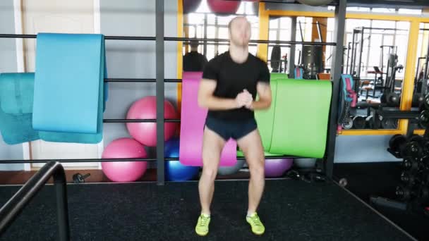 El hombre se encarga del calentamiento. Un joven atleta crossfit se prepara para el entrenamiento . — Vídeos de Stock