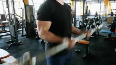 Kaslı adam yakın çekim içinde halter kaldırma. Sporcu bir spor salonunda ağırlık büyük elleriyle