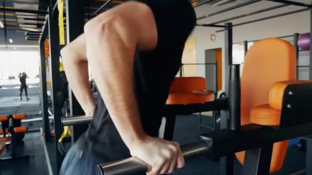 Gespierde sterke man push-ups in sportschool op parallelle staven — Stockvideo