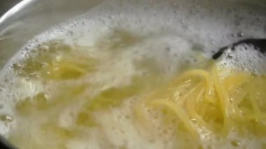 Yakın çekim karıştırma spagetti makarna bir tencerede kaynar su