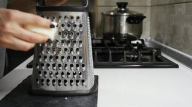 Spagetti yavaş hareket için metal rende üzerinde mozzarella peyniri sürtünme kadın