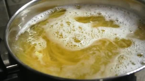 Macro primer plano: pasta de espaguetis cocida en agua hirviendo en cámara lenta — Vídeo de stock