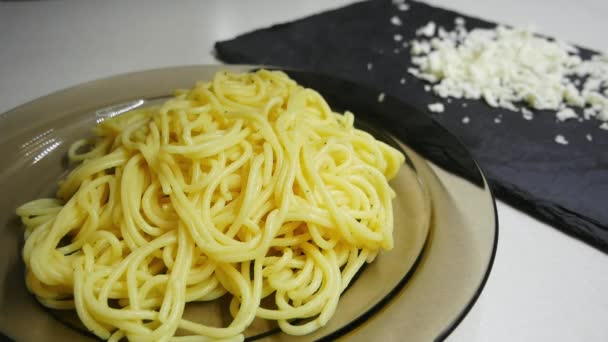 Woman hand sprinkle spaghetti with grated mozzarella cheese in slow motion — Stock Video