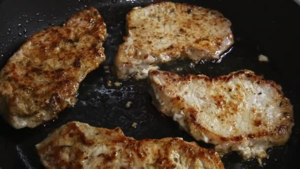 Il primo piano di costolette di carne di maiale è fritto in una padella per friggere. Costolette di maiale in una padella — Video Stock