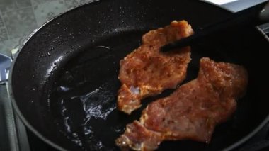 Bir tavada kızarmış Maşa ile bir tavada kız koyarak domuz pirzolası.