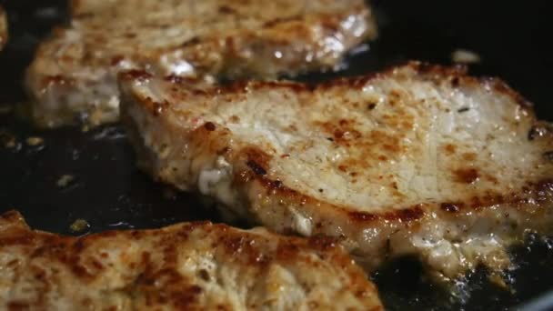 Macro close-up of pork chops in a skillet, fried in a frying pan — Stock Video