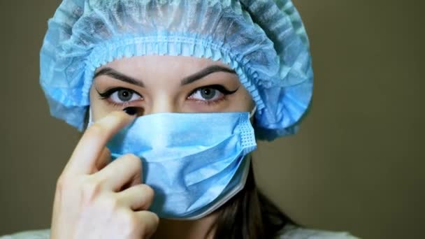 Mujer feliz médico mirando a la cámara, se quita la máscara y la sonrisa — Vídeo de stock
