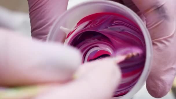 Primer plano artista mezcla púrpura, pintura blanca y rosa, preparándose para pintar . — Vídeos de Stock