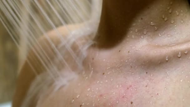 Une femme prend une douche dans le bain, arrosant sa poitrine — Video