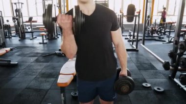 Atletik erkek kasları, pompalama spor salonunda vücut geliştirme egzersizleri yapıyor