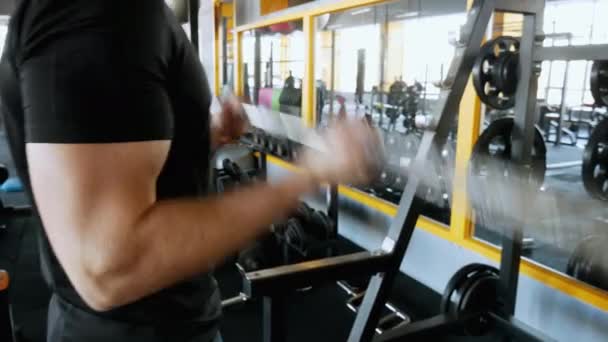 Hombre musculoso con grandes bíceps levantando la barra en primer plano — Vídeo de stock