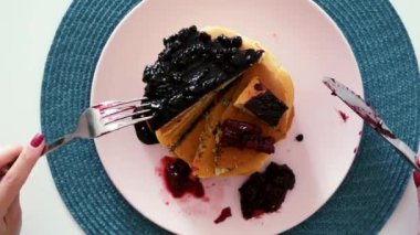 Sabah kahvaltı üst görünümünde. Bıçak ve çatal ile pancakes yemek kadın çilek