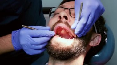 Close-Up diş Kliniği hastada. Diş hekimi hazırlamak adam diş diş doldurmak için