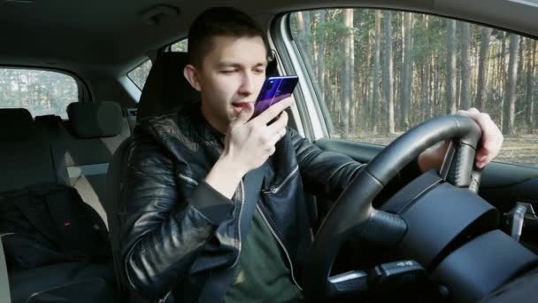 Hombre guapo hablando con el asistente de telefonía móvil. Buscando direcciones en un mapa móvil — Vídeos de Stock