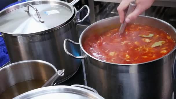 Un cuoco in un ristorante mescola borsch in una grande padella — Video Stock