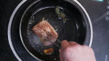 Şef restoranın mutfağında sıcak bir tavada et biftek dana eti pişiren, üstten görünümü