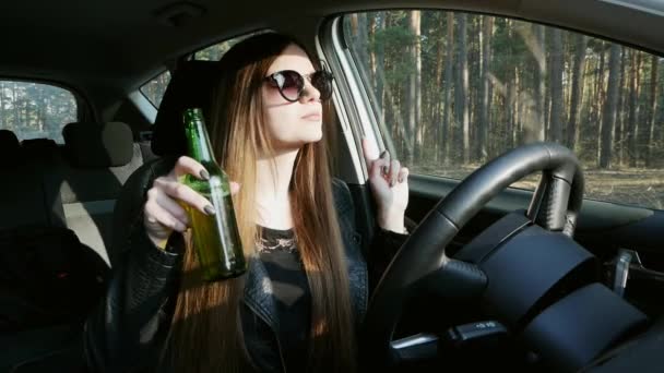 Mooi dronken meisje drinkt bier achter het stuur, dansen in de auto — Stockvideo