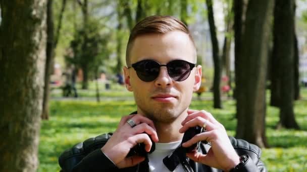 Close-up retrato de estudante atraente, homem coloca fones de ouvido ouvindo música — Vídeo de Stock