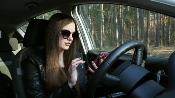 Güzel kız arabada bir cep telefonu kullanır — Stok video