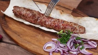Izgara lula kebap yakın çekim, geleneksel oryantal yemek, bıçak ve çatal ile kadın kesim