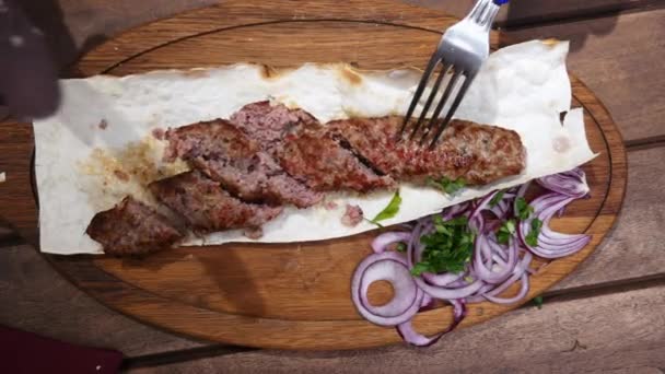 Pohled na grilovaný lulský kebab, tradiční orientální pokrm, dělené ženy s nožem a vidličkou — Stock video