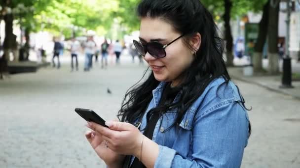 Молодая успешная студентка пользуется мобильным телефоном — стоковое видео