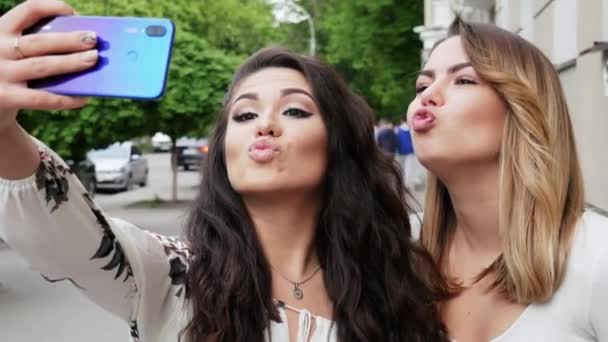 Dua model wanita cantik membuat selfie di telepon di jalan — Stok Video