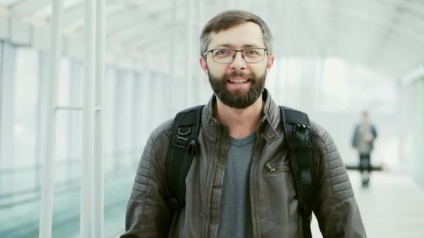 幸せな観光客の肖像画、空港で微笑むあごひげ男 — ストック動画