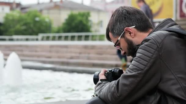 Αρσενικό με γένια τουρίστρια με κάμερα παίρνει ένα βίντεο στο πάρκο — Αρχείο Βίντεο