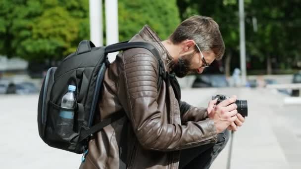 Bearded man met camera neemt een video in de straat van de stad — Stockvideo