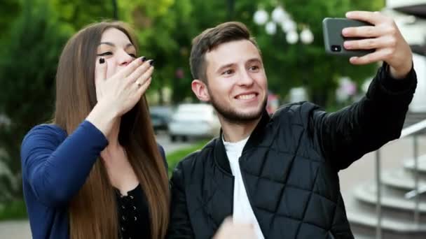 Feliz joven pareja en la calle teniendo video chat con amigos a través del teléfono celular — Vídeos de Stock