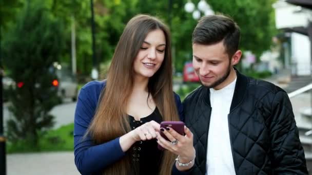 Fröhliche Frau zeigt einem Mann ein Foto, Spiel, Bewerbung, Online-Shopping — Stockvideo