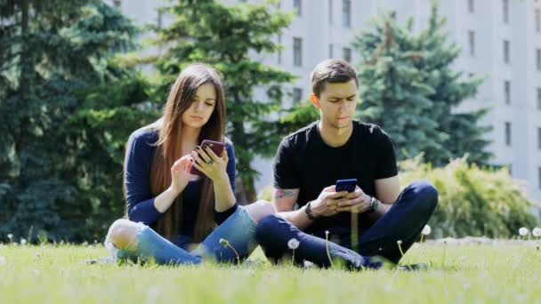 W zależności od ludzi telefonów, którzy korzystają z telefonu w parku, poważne uzależnienie od telefonów komórkowych — Wideo stockowe