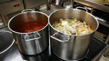 Restoranın mutfağında soba üzerinde çorba ile iki büyük tava