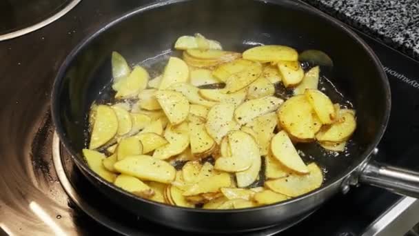 Kartoffeln in Öl in einer Pfanne in Zeitlupe in der Küche gebraten — Stockvideo