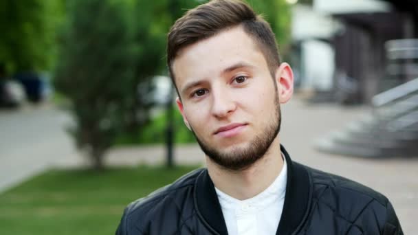 Retrato de cerca del hombre despreocupado, mirando a la cámara con mirada indiferente — Vídeo de stock