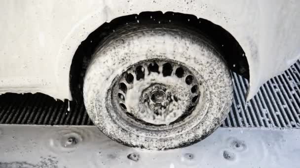 Primer plano de una rueda de coche de la que la espuma está drenando — Vídeo de stock