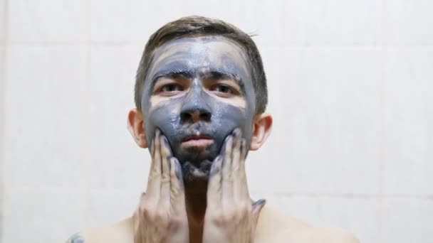 Uomo applica maschera crema nera sul viso contro l'acne — Video Stock