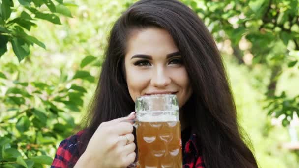 Joven hermosa chica sacia la sed, bebe cerveza y se lame los labios — Vídeos de Stock