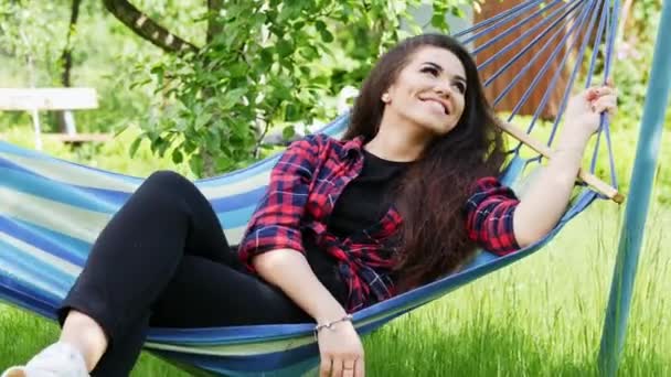 Preciosa joven disfrutando de unas vacaciones tumbada en una hamaca, chica feliz sonriendo — Vídeos de Stock