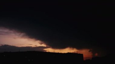 Büyük siyah yağmur buluttimelapse gün batımında şehir kapsar, bu mesafe yağmur başlar