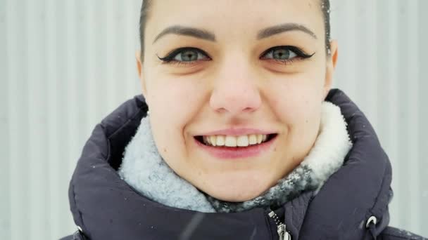 Close-up retrato de uma mulher feliz olhando para a câmera e sorrir em câmera lenta — Vídeo de Stock