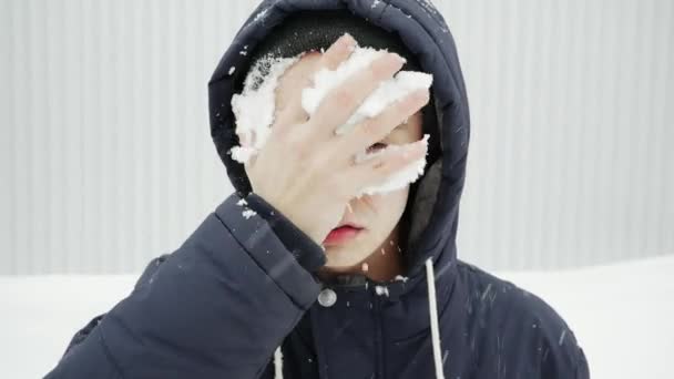Hombre enojado con trastorno neuropsiquiátrico y lesión ocular se limpia la cara con nieve en cámara lenta — Vídeo de stock