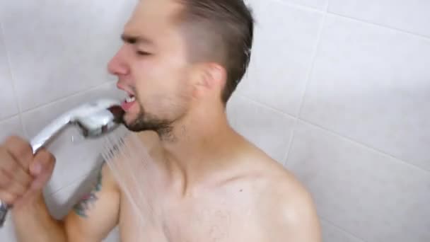 Portrait eines bärtigen Mannes lustig singt und tanzt im Badezimmer. Mann wäscht sich in der Dusche — Stockvideo