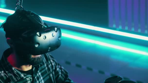 Bearded man använder modern Virtual Reality headset med gamepad, spela VR-spel — Stockvideo