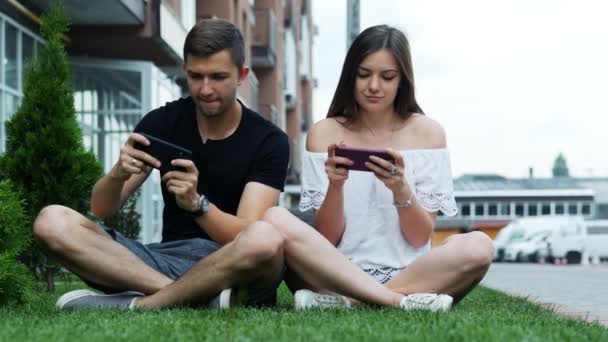 Glad och attraktiv par spela spel på mobiltelefon. Kaukasiska man och kvinna tillbringar fritid — Stockvideo