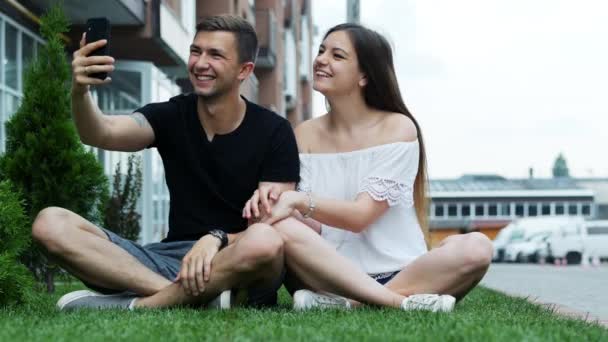 Šťastný mladý pár, který se dívá na smartphone, má video hovor, volání přátel nebo příbuzných, společenské sdělovací prostředky — Stock video