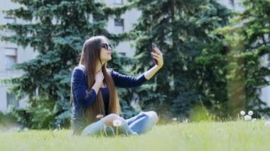 Çekici genç kadın görüntülü arama veya yaz parkında bir vlog çekim