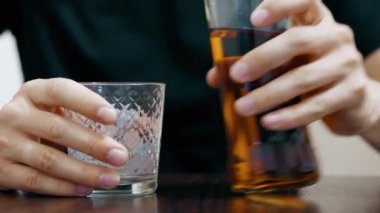 Yakın çekim: yalnız adam şişe ve içme cam viski döker