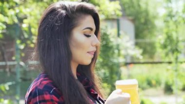 Genç mutlu kadın portresi bir barbekü de bahçede, camdan bira içecekler, susuzluk giderir